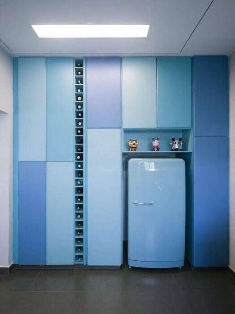 10. Uma decoração de cozinha planeja bem diferente, toda em azul e com adega na vertical.