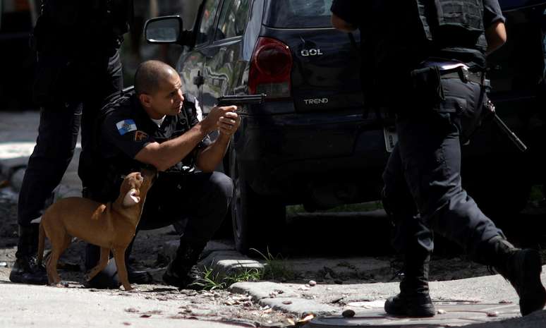 Policial se posiciona durante opera&ccedil;&atilde;o contra traficantes na Cidade de Deus, no Rio de Janeiro