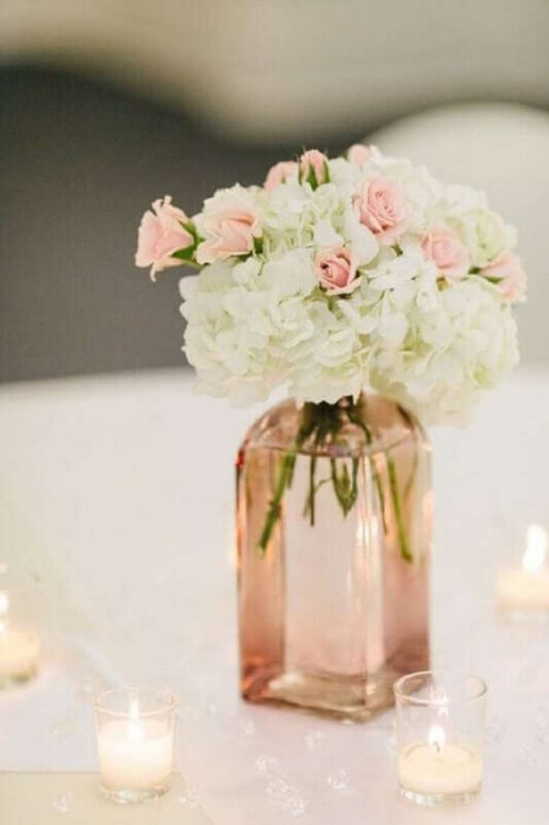 41. Vasinhos de vidro com flores é uma ótima opção de decoração de casamento simples e barato