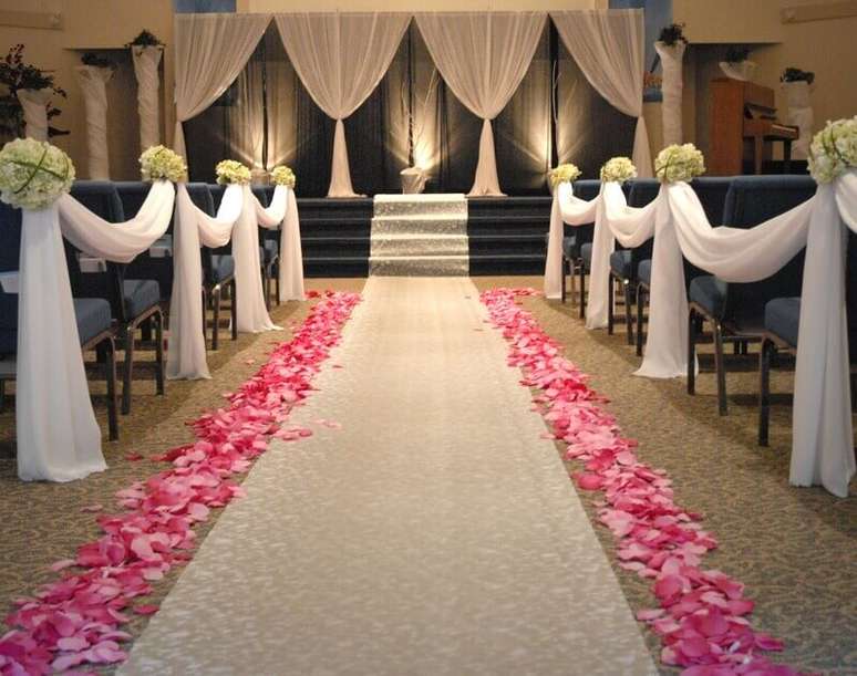 46. As pétalas de rosas ao longo da nave podem deixar a decoração de casamento simples mais romântica