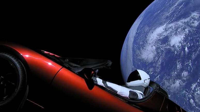 Aqui vemos o Tesla Roadster, o traje Starman e a Terra ao fundo (Reprodu&ccedil;&atilde;o: Divulga&ccedil;&atilde;o)