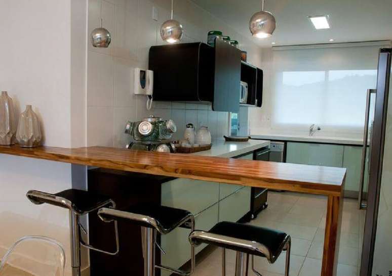 21. Essa cozinha americana simples ganhou modernidade com os pendentes e charme com a bancada de madeira