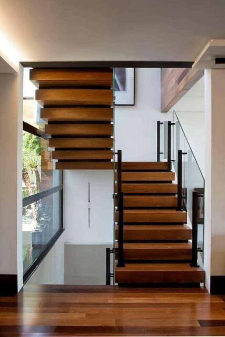 13. Nesta escada temos o uso de três materiais comuns em casas modernas: madeira, ferro e vidro. Projeto de Elmor Arquitetura