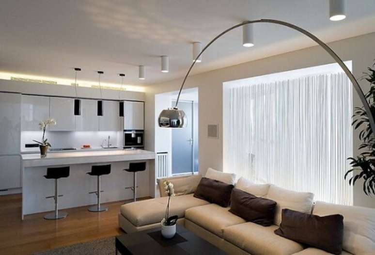 6. Nesta casa moderna, a lumin&aacute;ria arco chama aten&ccedil;&atilde;o na sala