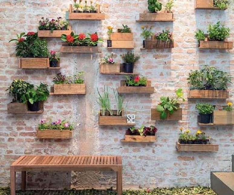 50. Esse jardim vertical ficou bem delicado com tantos vasinhos