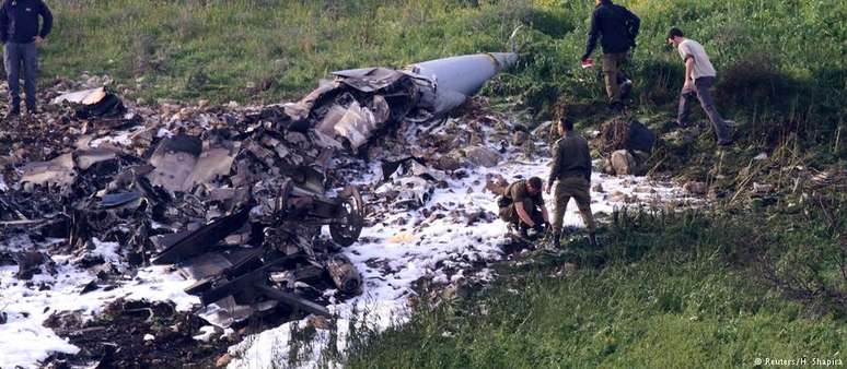 Militares observam destroços de aeronave israelense que caiu neste sábado. 