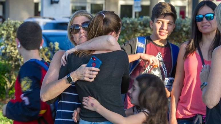 Familiares e crianças se abraçam nos arredores da escola pública Marjory Stoneman Douglas; ataque deixou pelo menos 17 mortos