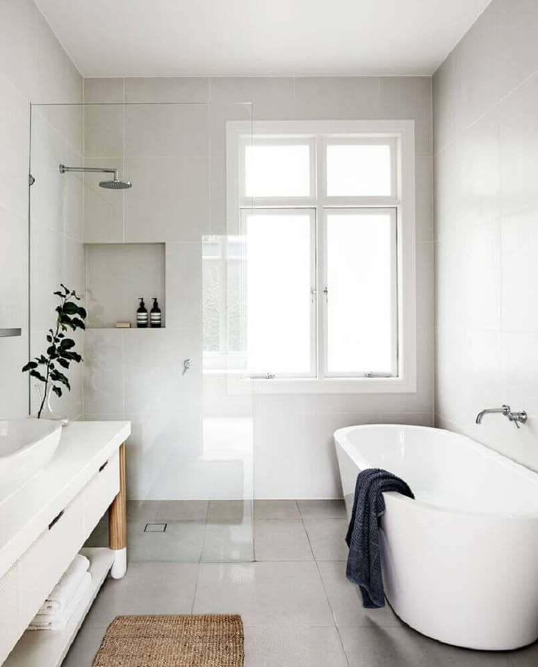 36. Lindo banheiro minimalista com banheira de apoio
