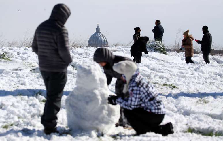 Pessoas brincam com neve perto da Bas&iacute;lica de S&atilde;o Pedro em Roma
 26/2/2018   REUTERS/Alessandro Bianchi