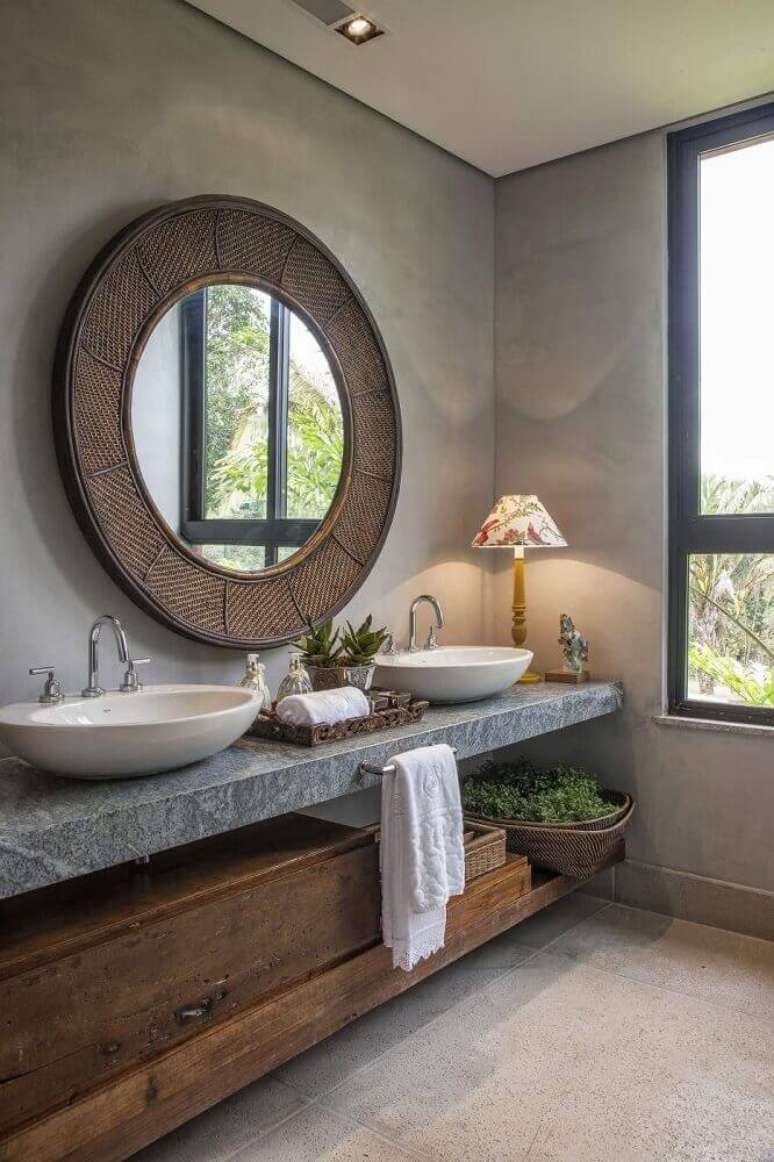 42. Linda decoração de lavabo com espelho redondo e parede de cimento queimado.