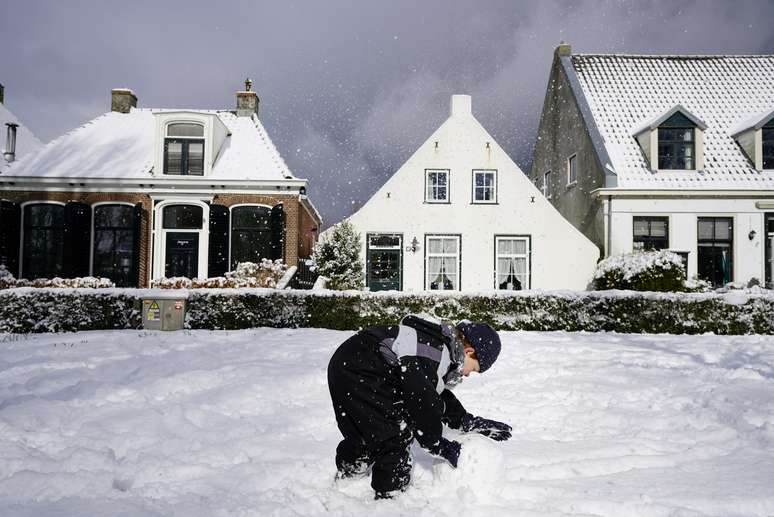 Criança brinca com a neve na Holanda