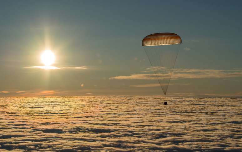 Capsula Soyuz abre o paraquedas após a reentrada na atmosfera da Terra