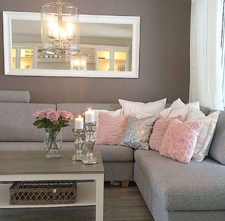 11. Sala decorada com sofá de canto cinza e almofadas para sofá cinza em tons de rosa e branco, trazendo delicadeza e elegância para o ambiente.