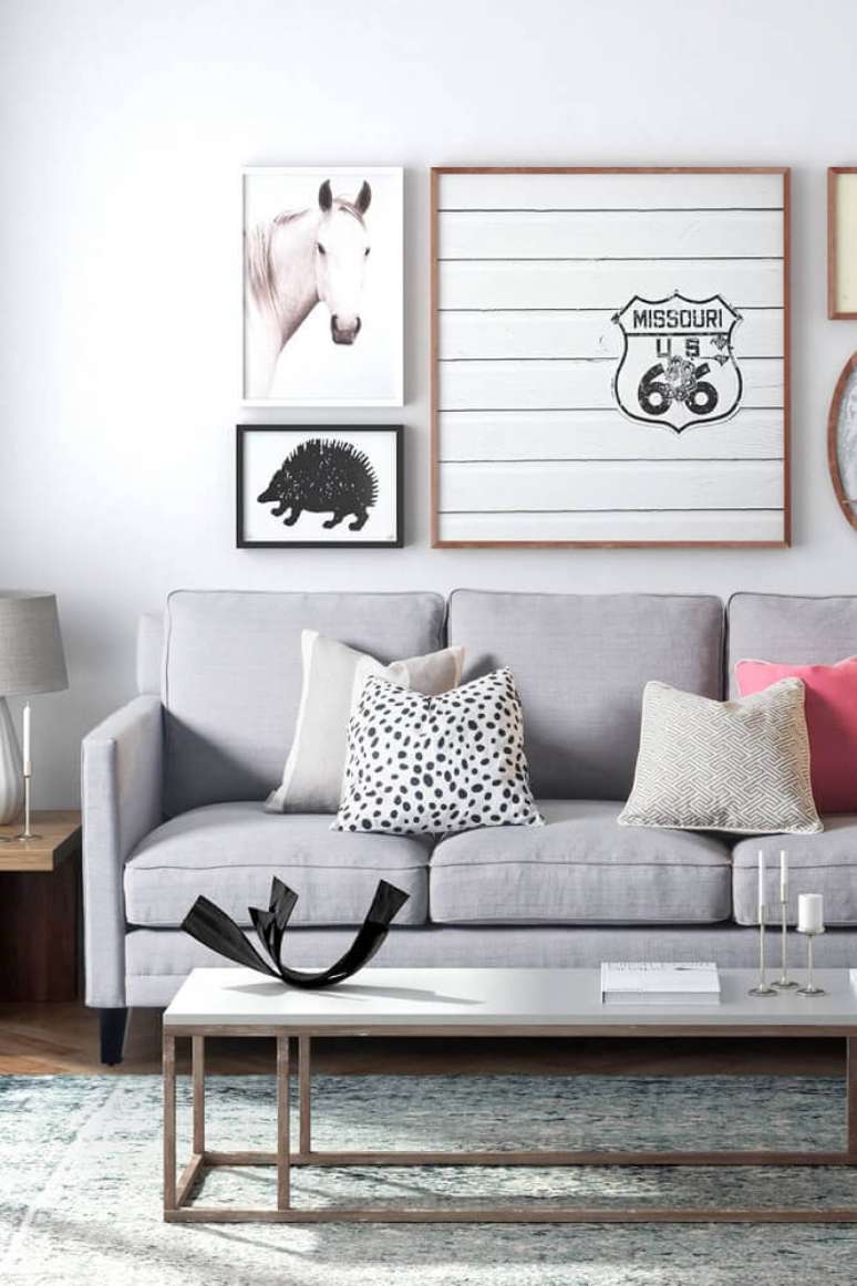 49. Decoração de sala minimalista com quadros e sofá cinza