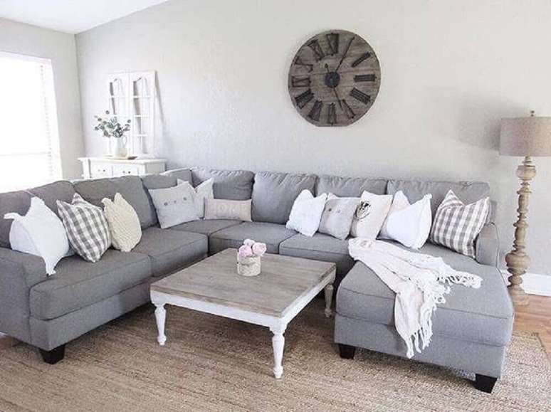 16. O sofá de canto cinza aliado com muitas almofadas é garantia de bastante conforto para a sala.