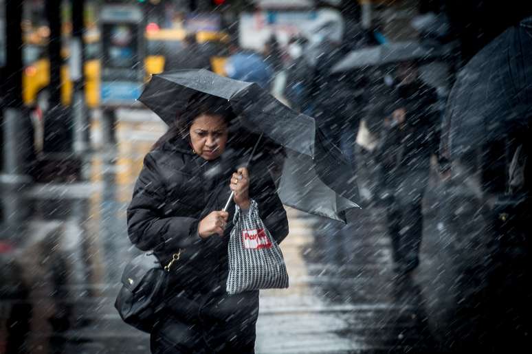 Pedestre atravessa a Broadway durante uma tarde de chuva em Manhattan. 