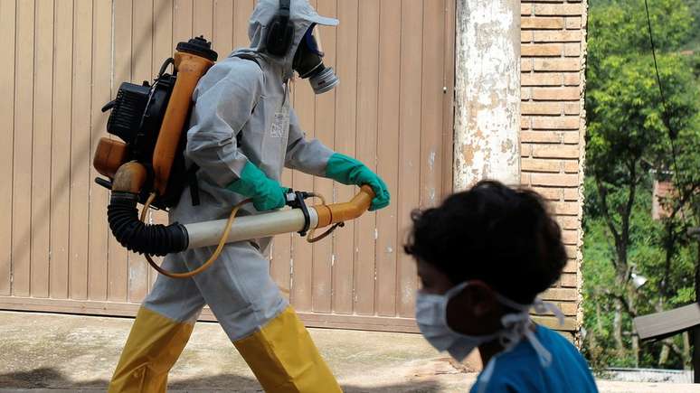 Agente de controle de vetores e menino com máscara se cruzam em São Paulo; imunização contra febre amarela gera dúvidas e por vezes boatos