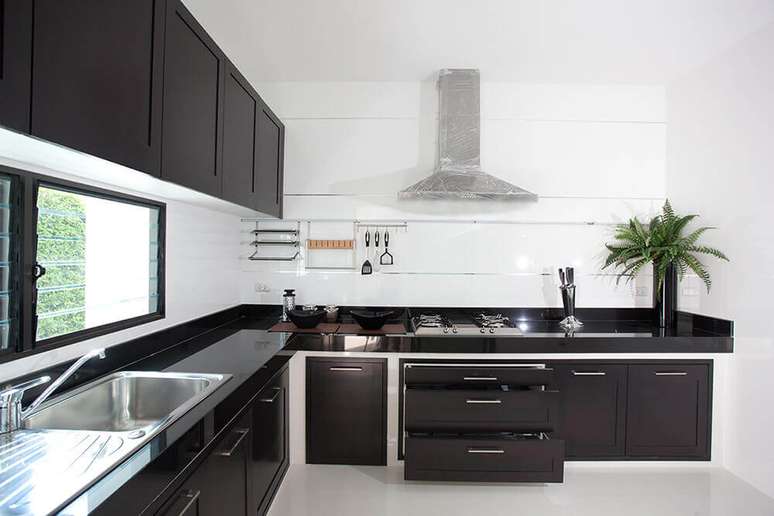 17. Cozinha moderna planejada com bancada preta.