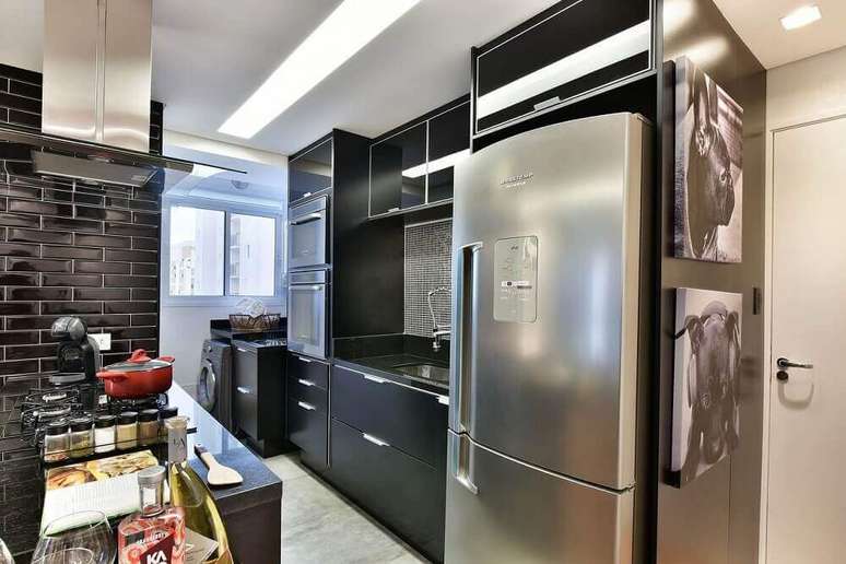 30. O ladrilho hidráulico preto é um tipo de revestimento parede cozinha moderna muito utilizado
