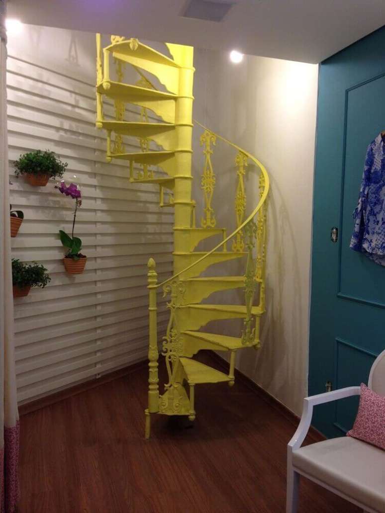 8. A escada caracol de ferro pintada de amarelo ganhou bastante destaque na decora&ccedil;&atilde;o desse ambiente.