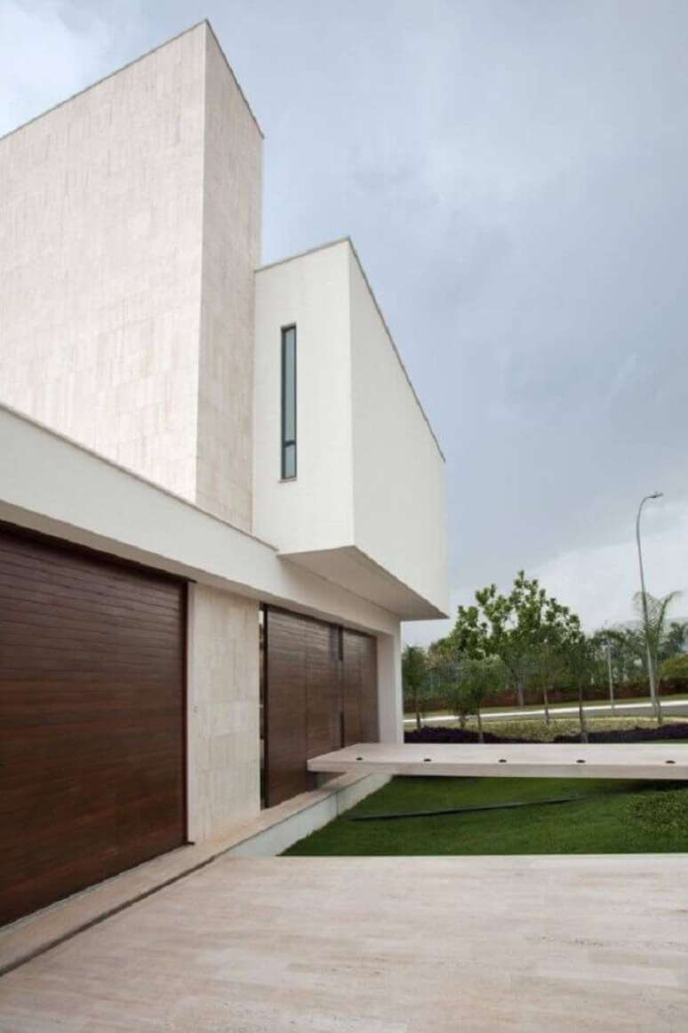 29. Fachada de muro minimalista com port&atilde;o de madeira