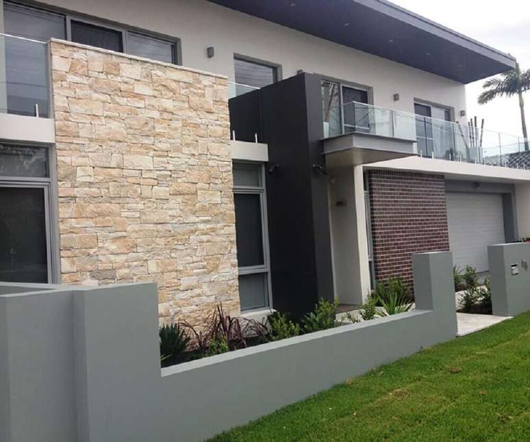 15. O mix de revestimentos para fachada de muro deixa a frente de casas com muro mais moderna