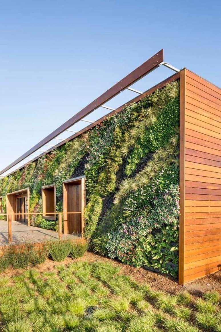 7. O muro verde combina muito bem com materiais como madeira e tijolo à vista, assim, garantindo uma frente de casas com muito mais rústica.