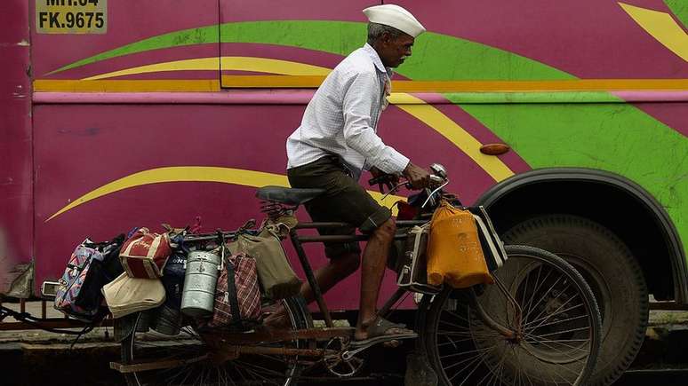 Os dabbawalas, entregadores de quentinhas, levam marmitas quentes onde quer que seja em Mumbai | Foto: AFP