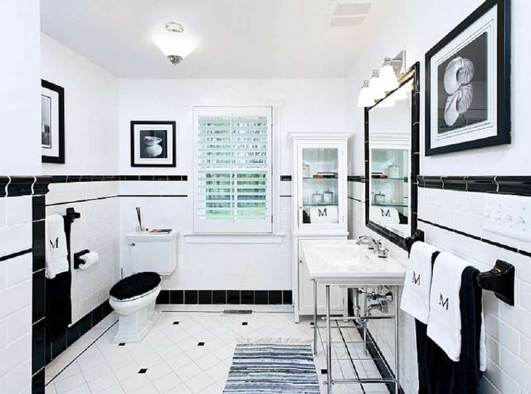 11. Banheiro preto e branco com quadros e espelho.