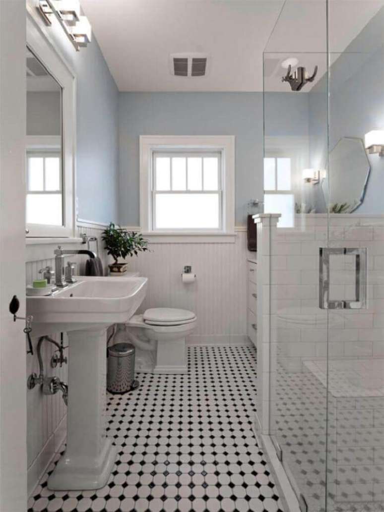34. Modelo de banheiro branco com detalhes pretos no piso.