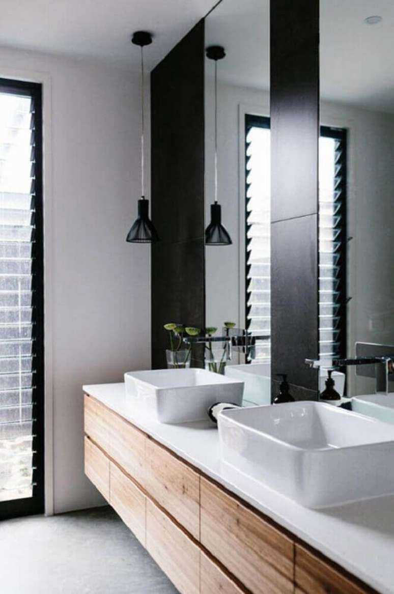 13. Os detalhes em madeira no banheiro preto e branco deixam o espaço mais aconchegante.