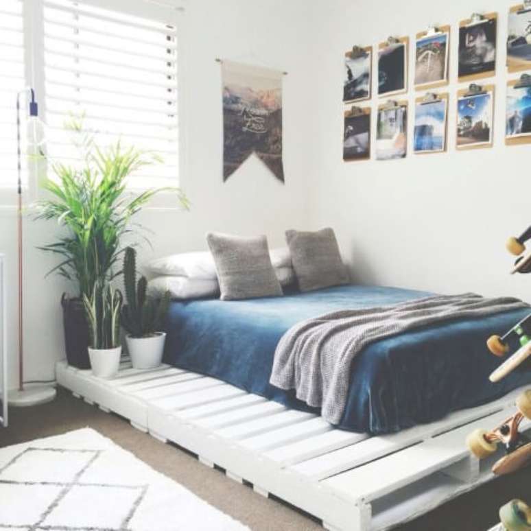 28. Cama de pallet branca com espaço extra aproveitado com plantas