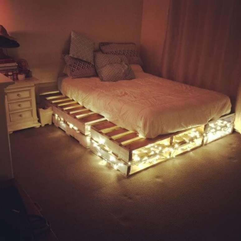 27. Cama de casal de pallet com espaço sobrando e luzes