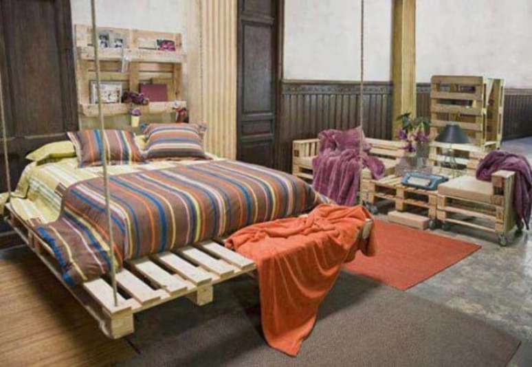 25. Cama feita de pallet em quarto com outros móveis também de pallet