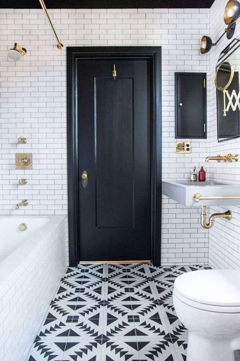 28. Banheiro preto e branco retrô com detalhes em dourado e piso desenhado