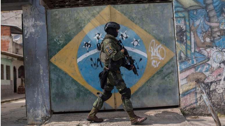 Militar participa de opera&ccedil;&atilde;o no Rio de Janeiro; relat&oacute;rio mostra que exposi&ccedil;&atilde;o &agrave; viol&ecirc;ncia afeta percep&ccedil;&atilde;o da felicidade na Am&eacute;rica Latina