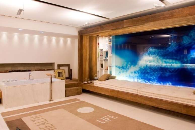 6. Este banheiro de luxo projetado por Marilia Veiga conta com uma banheira e um longo futton