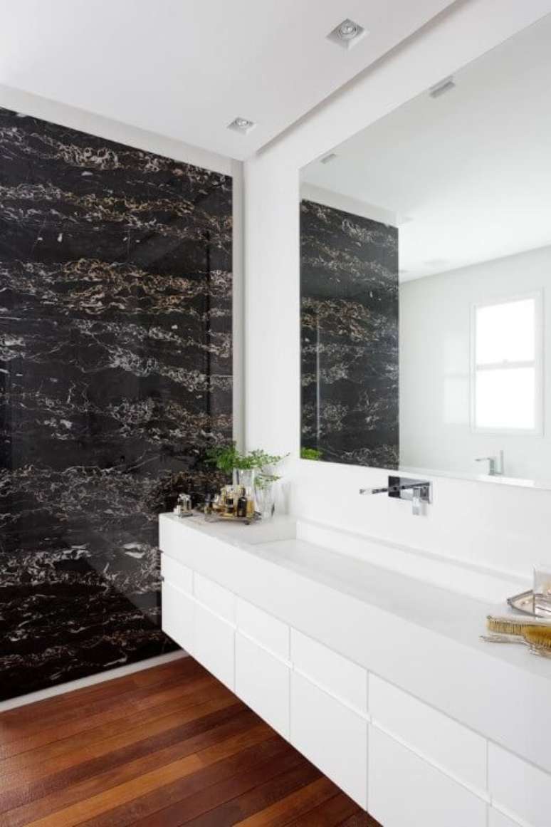 69. Banheiro de luxo com piso de madeira e revestimento de m&aacute;rmore. Projeto de Consuelo Jorge