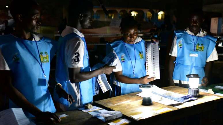 Funcionários da justiça eleitoral de Serra Leoa fazem a contagem de votos manualmente (Foto: Issouf Sanogo / AFP)