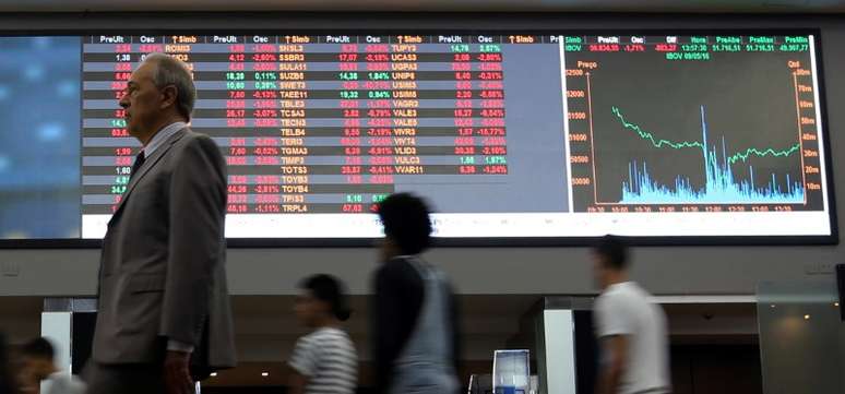 Pessoas passam por gráfico de flutuações do mercado na Bovespa, no centro de São Paulo, Brasil 09/05/2016 REUTERS/Paulo Whitaker