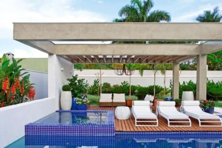 37. O deck de madeira contrasta muito bem com o azul do revestimento da piscina. Projeto de Fernando Roma