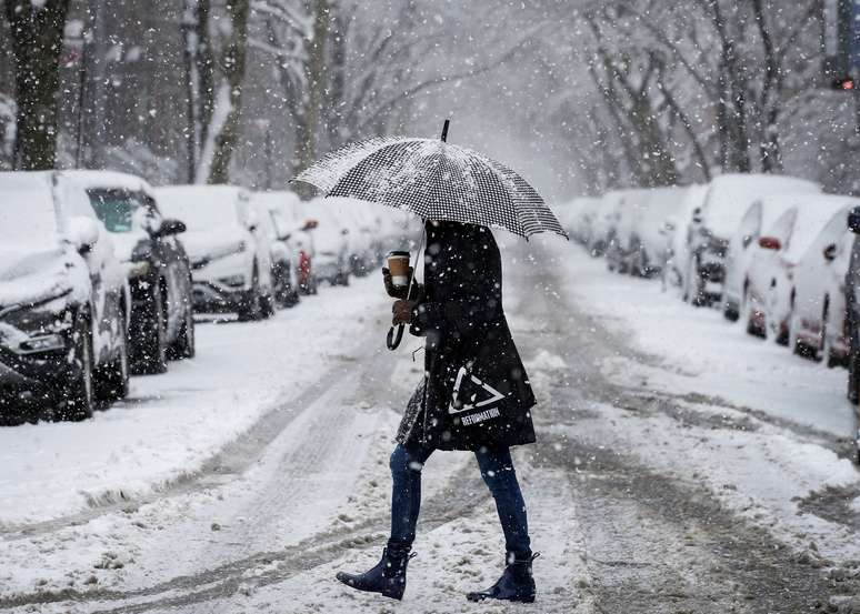 Mulher caminha em meio à neve em rua do Brooklyn, em Nova York