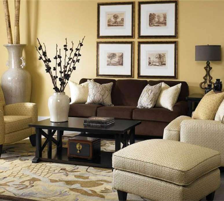 3. Sofá marrom com almofadas claras para um ambiente mais sofisticado.