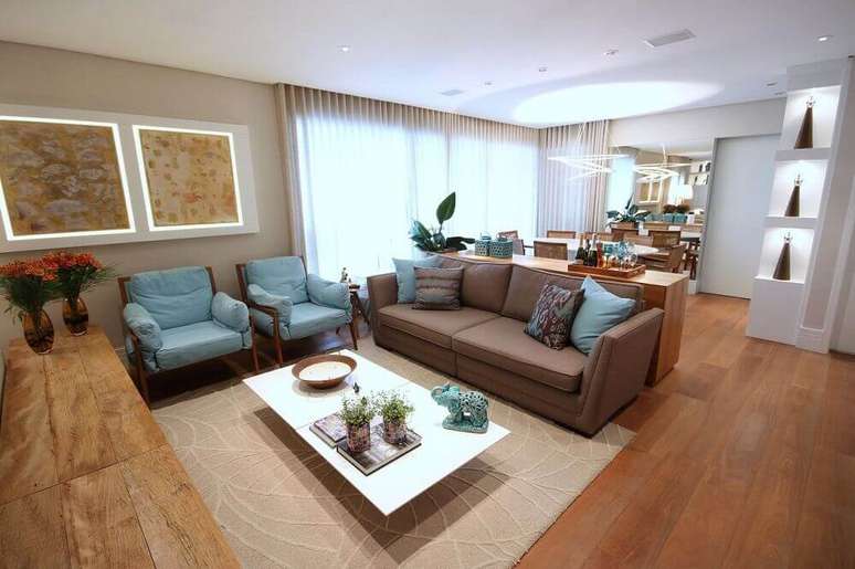 37. Decoração de sala com sofá marrom e almofadas azuis e estampadas
