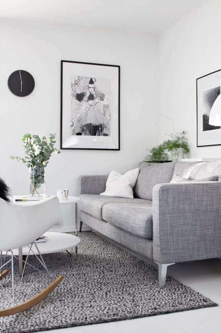 1. Decoração de sala com sofá cinza e quadro na parede.