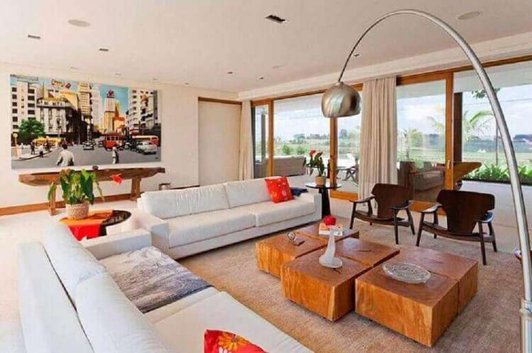 32. Sala de estar decorada com elementos modernos e r&uacute;sticos como a modelos de mesa de centro de madeira