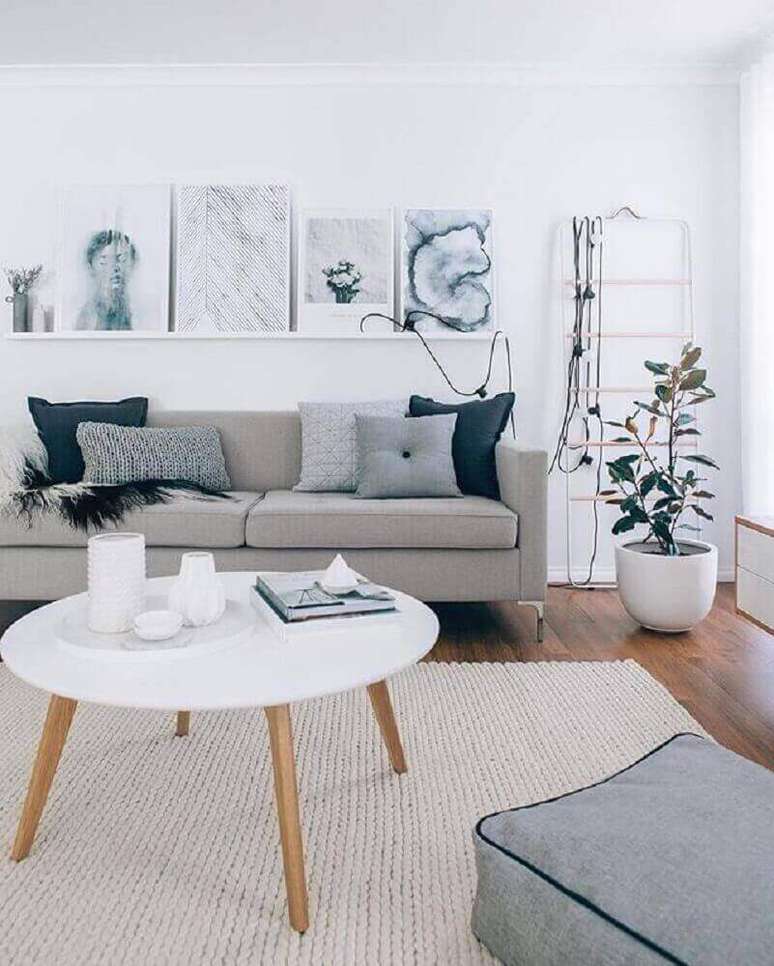 9. Decoração estilo escandinavo em sala com sofá cinza.