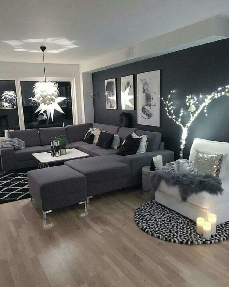 35. Sala com parede preta e sofá cinza