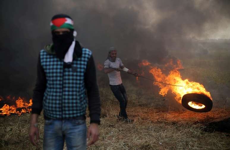 Manifestante palestino move pneu em chamas durante confronto com soldados israelenses na fronteira entre Israel e Gaza 05/04/2018 REUTERS/Ibraheem Abu Mustafa