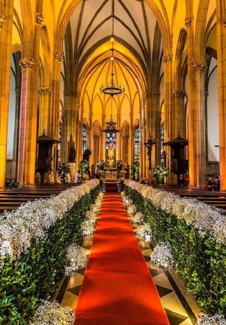 3. Tradicional decoração de igreja para casamento em tons de branco e verde com o tapete vermelho.